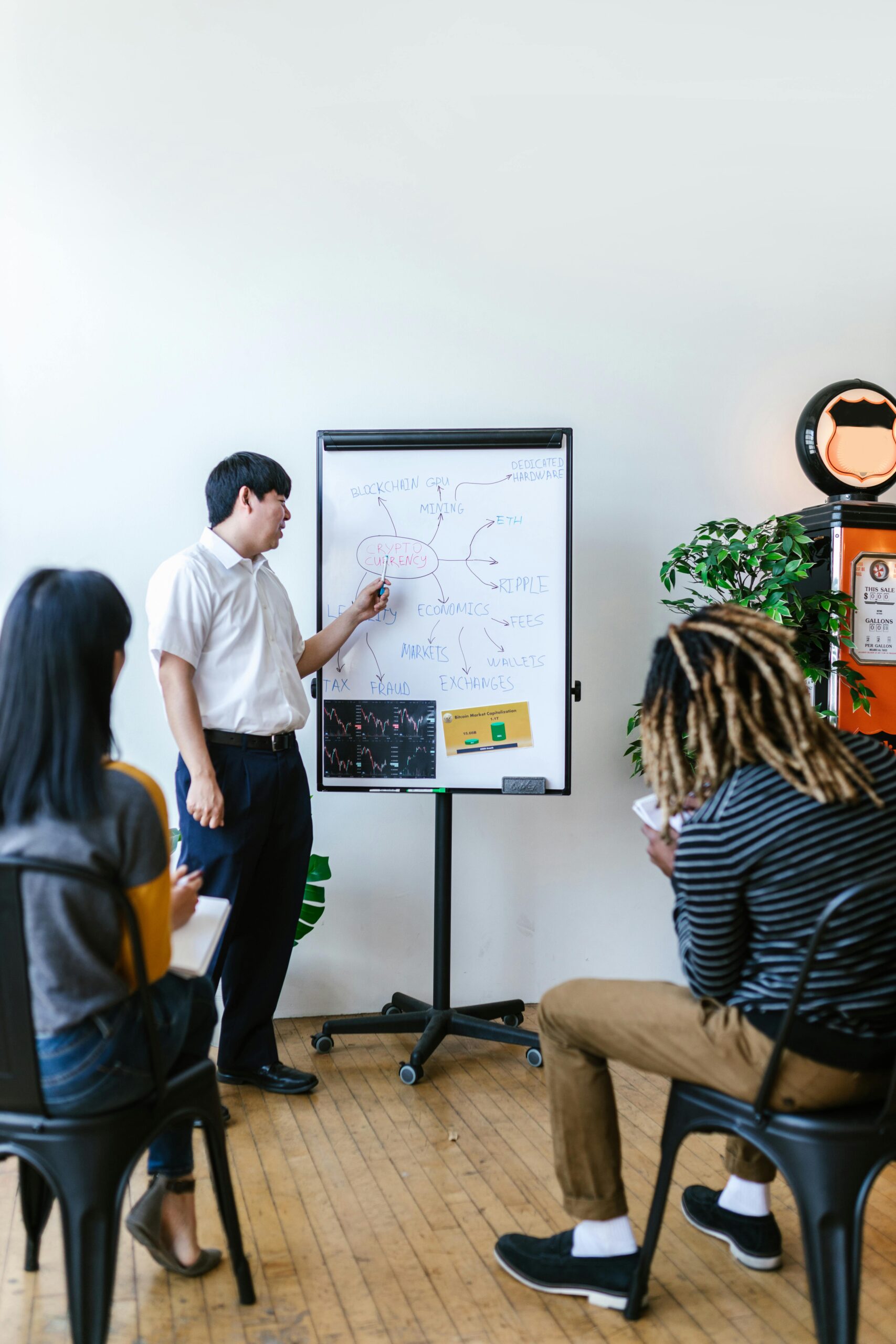 Trainer giving a presentation on blockchain concepts to a diverse group in a modern office.
